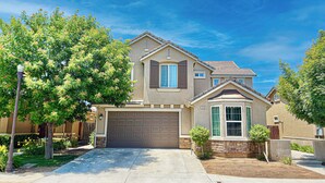 A two-story house with a garage, a small front yard, and a tree. - Clovis Gem – 4BR, 3.5 Bath (Clovis)