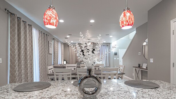 A modern kitchen with granite countertops, a central island, and pendant lighting. - Clovis Gem – 4BR, 3.5 Bath (Clovis)
