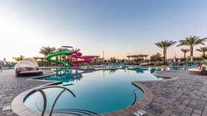 A swimming pool with a water slide, lounge chairs, and palm trees. - New Modern Luxury 8-bed mins to AAG, Fwy, Clubhouse. Ideal Sports or Ext Stay  (Mesa)