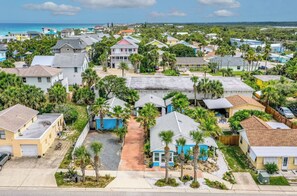 Un quartier résidentiel avec des maisons, des palmiers et une vue sur l’océan.