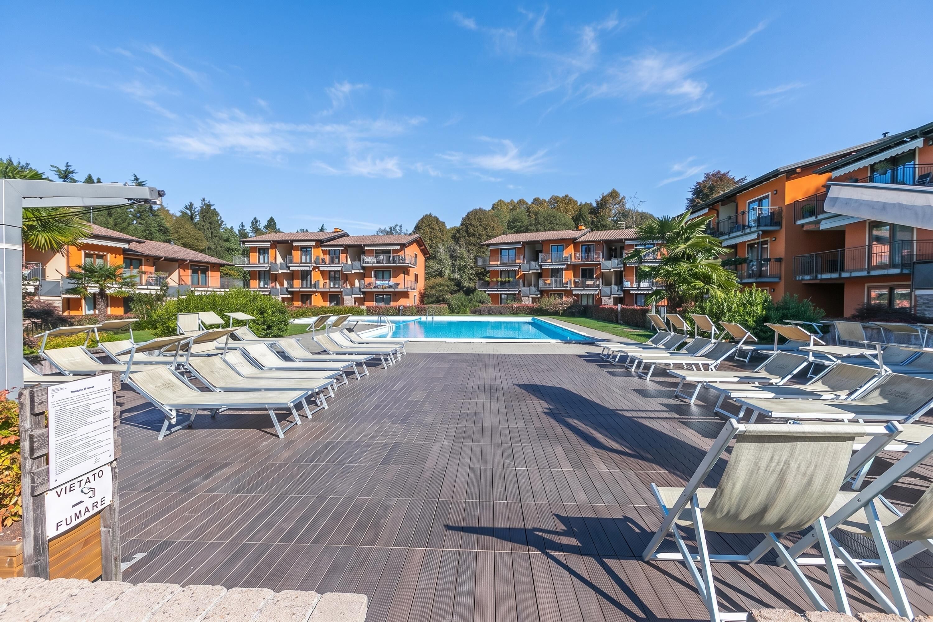 A poolside area with sun loungers and a swimming pool.