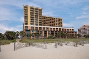 Ein mehrstöckiges Hotel mit modernem Design, das Balkone und große Fenster bietet.