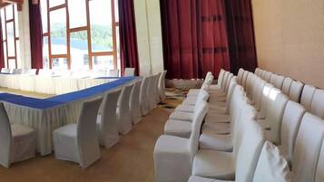 A conference room with a long table and rows of chairs.