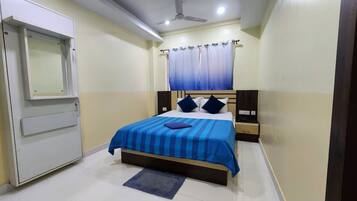A bedroom with a bed, a nightstand, a dresser, a ceiling fan, and a window with curtains.