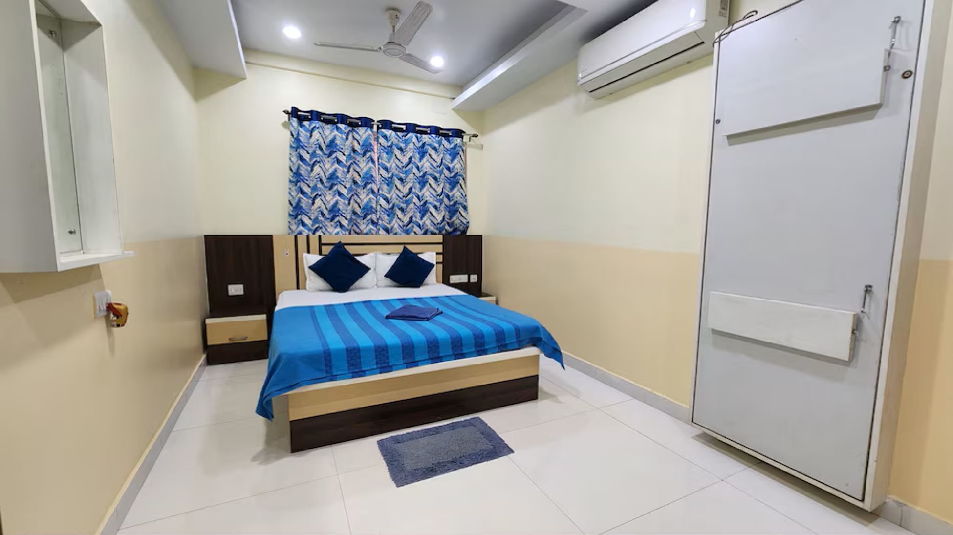 Un dormitorio con una cama, un armario, un ventilador de techo y un equipo de aire acondicionado.