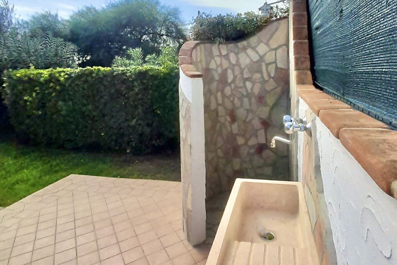 A bathroom with a stone wall, a sink, and a tiled floor.