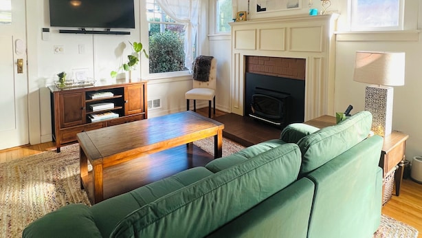 Una sala de estar con un sofá verde, una mesa de centro de madera y una chimenea.