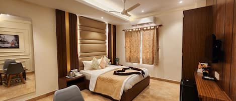 Una habitación de hotel moderna con cama, escritorio, silla, televisor y ventilador de techo.