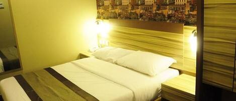 A hotel room with a bed, a nightstand, and a wall with a patterned mural.