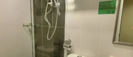 A bathroom with a glass-enclosed shower, a white toilet, a sink, and a towel rack.