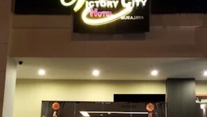 The exterior of Victory City Hotel with a prominent illuminated sign, a set of stairs leading to the entrance, and a reception desk visible through the glass doors. - Victory City Hotel Crystal Bay (Johor Bahru)