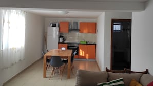 A compact living space with a dining area, kitchen, and a sofa. - Apartment Ela (Sveti Filip i Jakov)
