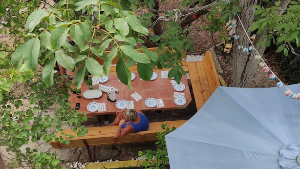 A wooden table set outdoors with plates and cutlery. - Apartment Ela (Sveti Filip i Jakov)