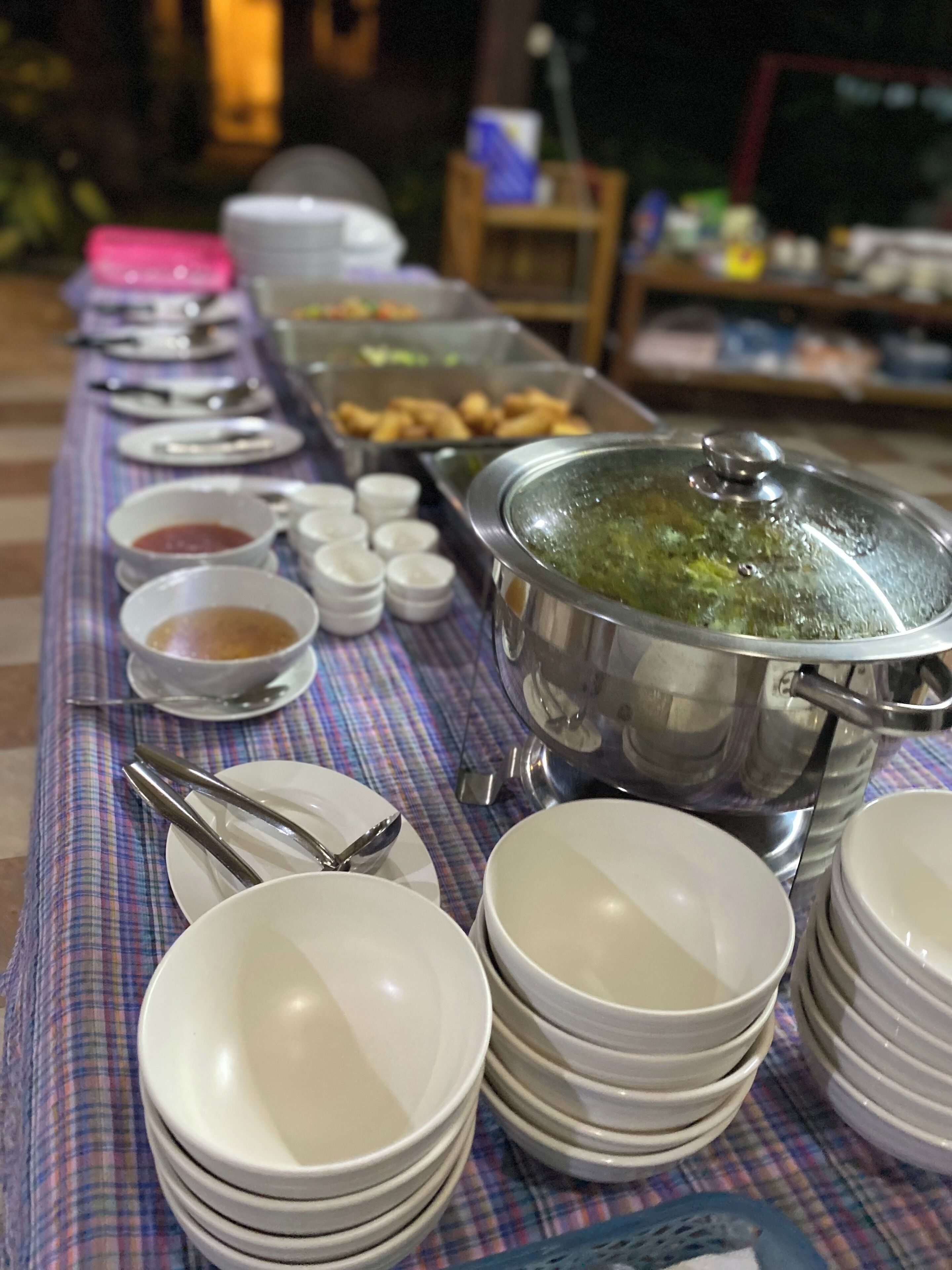 A buffet table with various dishes and condiments.