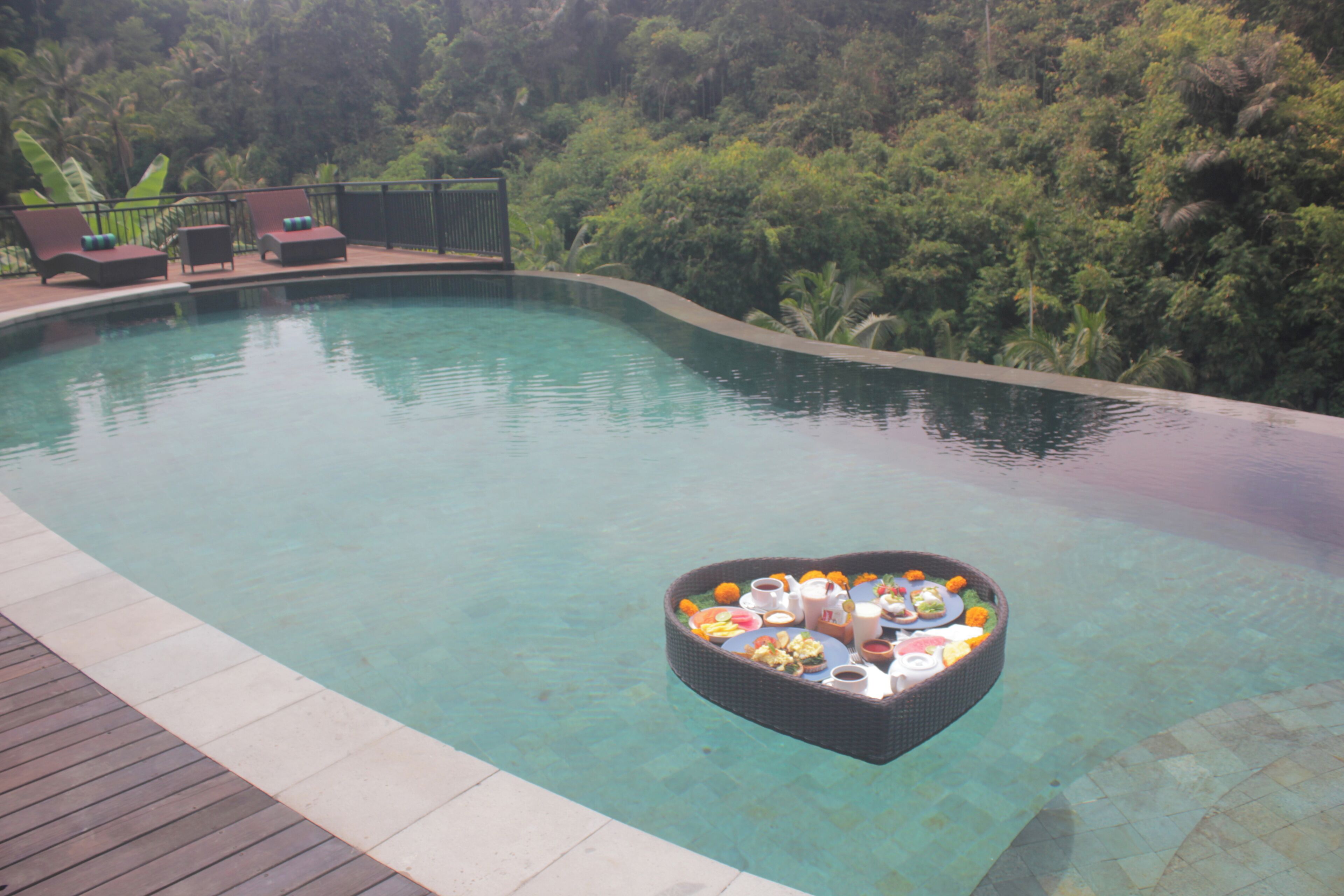 A pool with a floating bar area containing food and drinks.