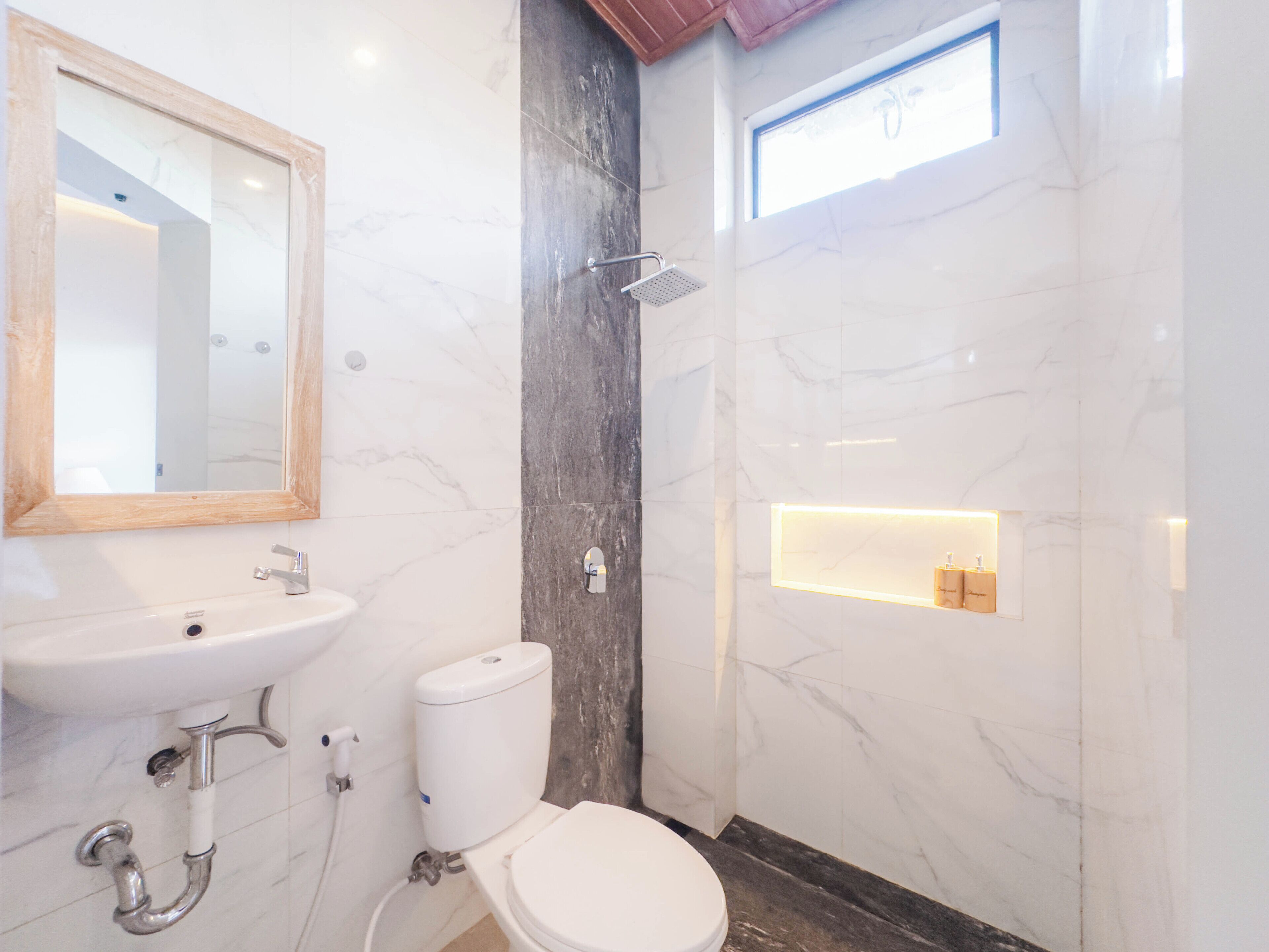 A bathroom with a marble sink, toilet, and shower.