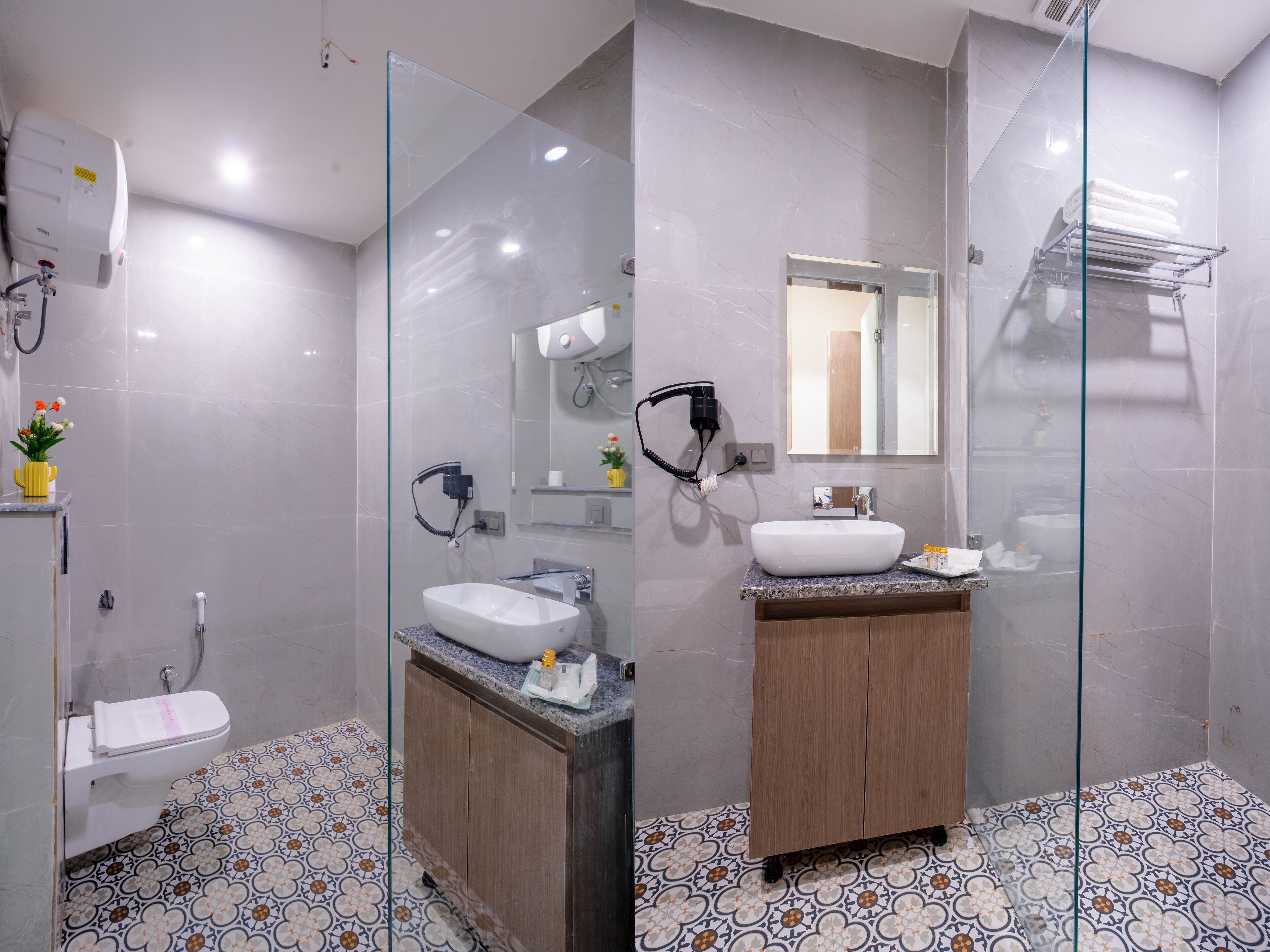 A modern bathroom with a glass shower enclosure, a white sink, and a wooden vanity.