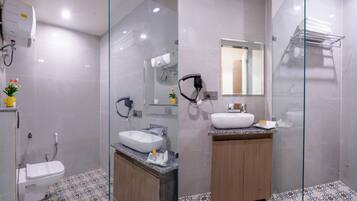A modern bathroom with a glass shower enclosure, a white sink, and a wooden vanity.