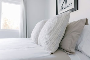 A neatly made bed with white bedding and two large, textured pillows. - Side-by-Side Homes - Near Zoo & Gaslamp (San Diego)