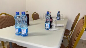 A conference room with a white table, metal chairs, and water bottles labeled 'Amoria'. - Amoria Boutique Hotel (Tigoni)