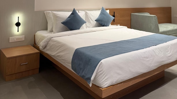 Une chambre moderne avec un grand lit, des tables de chevet, un ventilateur de plafond et des luminaires encastrés.