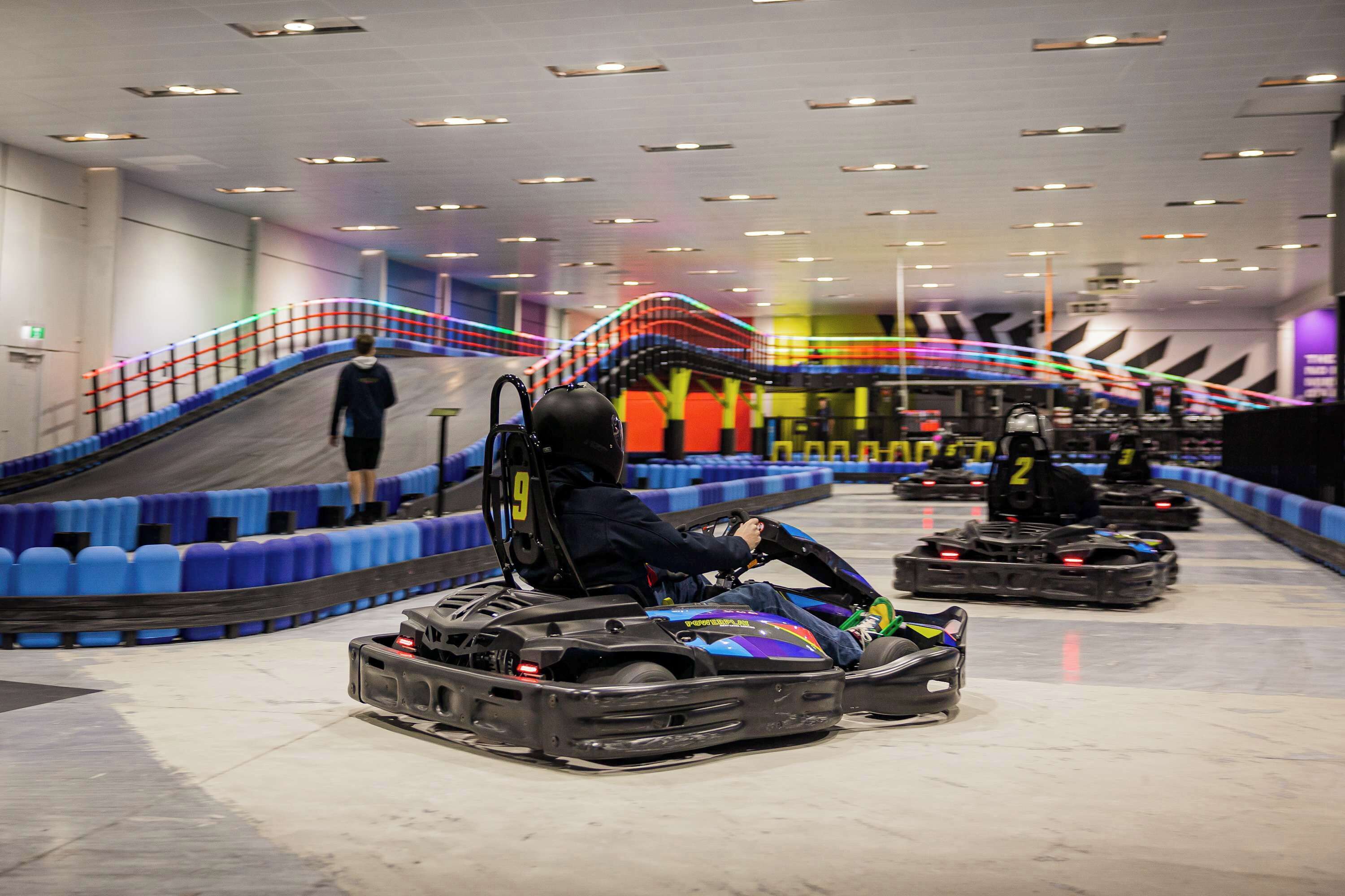 Una pista de carreras de karts con varios karts y una persona conduciendo.