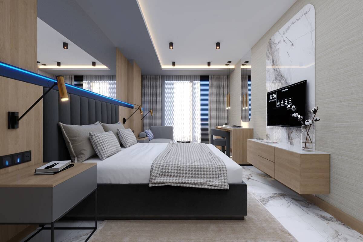 A modern bedroom with a bed, bedside tables, a TV, and a marble wall.
