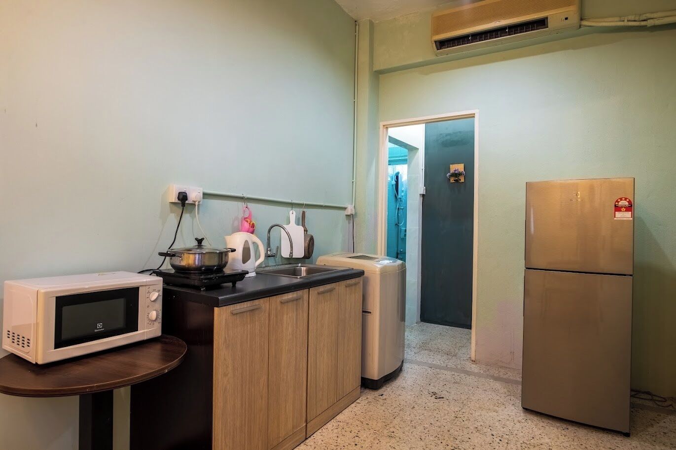 A compact kitchen with a microwave, stove, sink, and refrigerator.