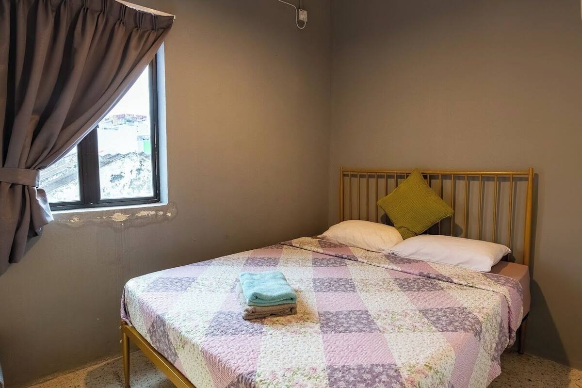 A single bed with a wooden frame and a quilted bedspread.