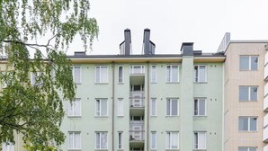 A multi-story residential building with a central staircase, surrounded by greenery and trees. - Stylish Studio in the Heart of Kallio (Helsinki)