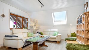 Una sala de estar moderna con un sofá, una mesa de centro de madera, una estantería y una ventana.
