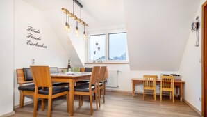Un comedor con muebles de madera, una ventana con adornos de corazones y una pared con texto.
