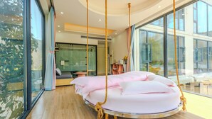 A modern bedroom with a circular hanging bed, large windows, and a view of the outdoors. - Harbor Diary Homestay (Xuancheng)