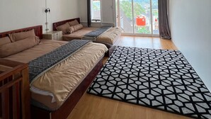 Un dormitorio con techo inclinado, piso de madera y un ventanal con vistas al exterior.