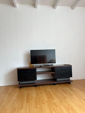 Un meuble de rangement en bois, doté d’un téléviseur à écran plat, de deux tiroirs et d’une étagère.