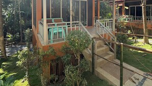 A two-story building with a covered patio area, a staircase, and a small garden. - Echo Samadhi (Ko Lanta)