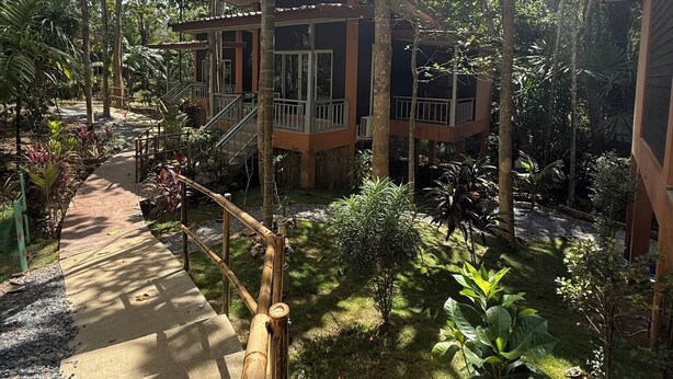 A building with a covered walkway surrounded by lush greenery. - Echo Samadhi (Ko Lanta)