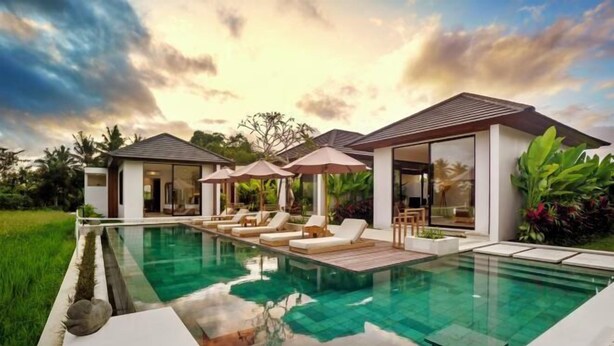A modern poolside area with lounge chairs, umbrellas, and a clear pool. - Villa Samaddhi by BaliSuperHost (Bali)