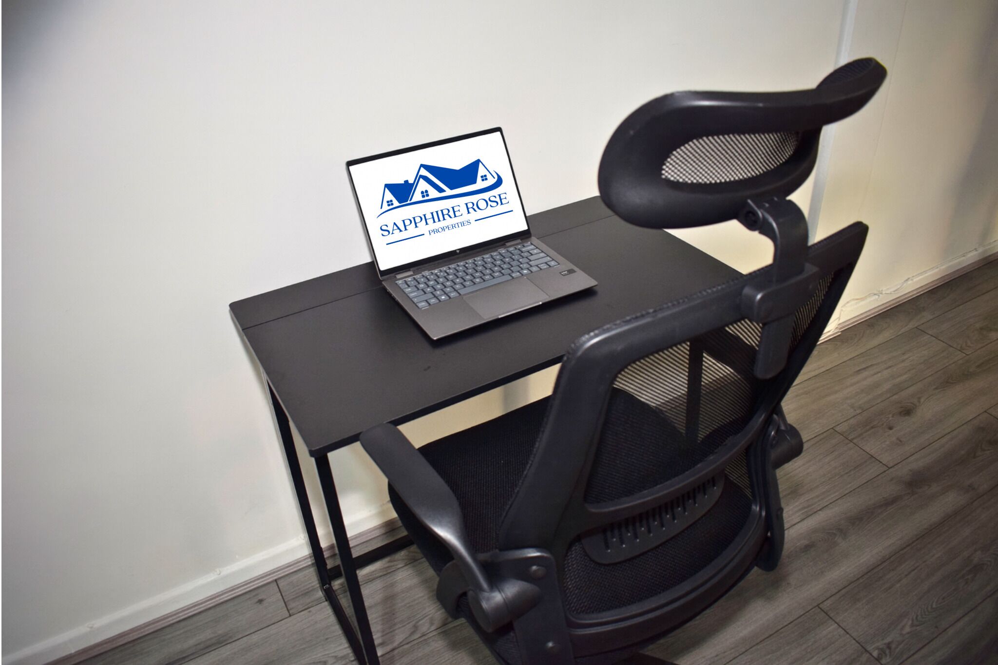 A laptop on a small table with a chair beside it.