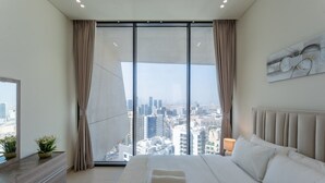 Una camera da letto moderna con un letto grande, vista sulla città e arredamento minimalista.