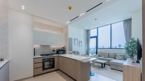 Un appartamento moderno con cucina, zona giorno e ampie finestre che offrono vista sulla città.