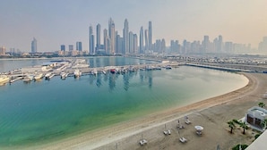 A coastal cityscape with a marina, boats, and high-rise buildings. - Classic 2 Bedroom l Marina Views l Private Beach (Emaar Beachfront)