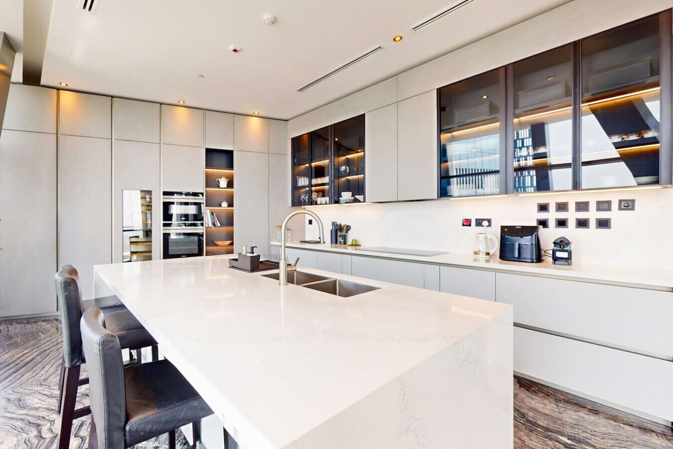 Een moderne keuken met een centraal eiland, inbouwapparatuur en een strak design.