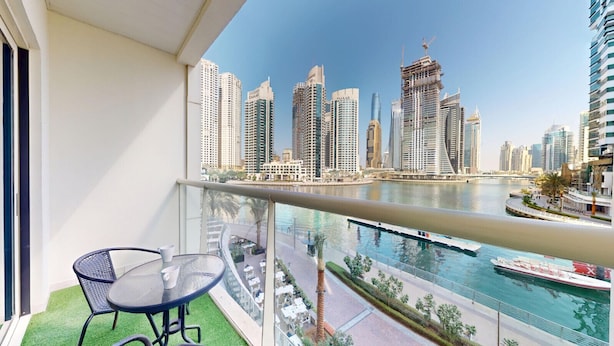 Ein Balkon mit Blick auf eine Stadtlandschaft, ein Gewässer und ein Boot.