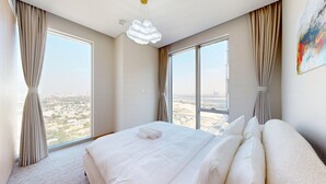 A hotel room with a large bed, two windows, and a view of a cityscape. - 2 Bed Direct Dubai Mall Access l Free Pool, Gym (Downtown Dubai)