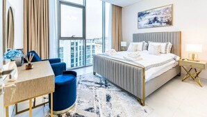 Une chambre d’hôtel moderne dotée d’un grand lit, d’un bureau, d’une chaise et offrant une vue sur la ville grâce à de grandes fenêtres.