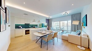 Een modern appartement met keuken, eethoek en woonkamer.