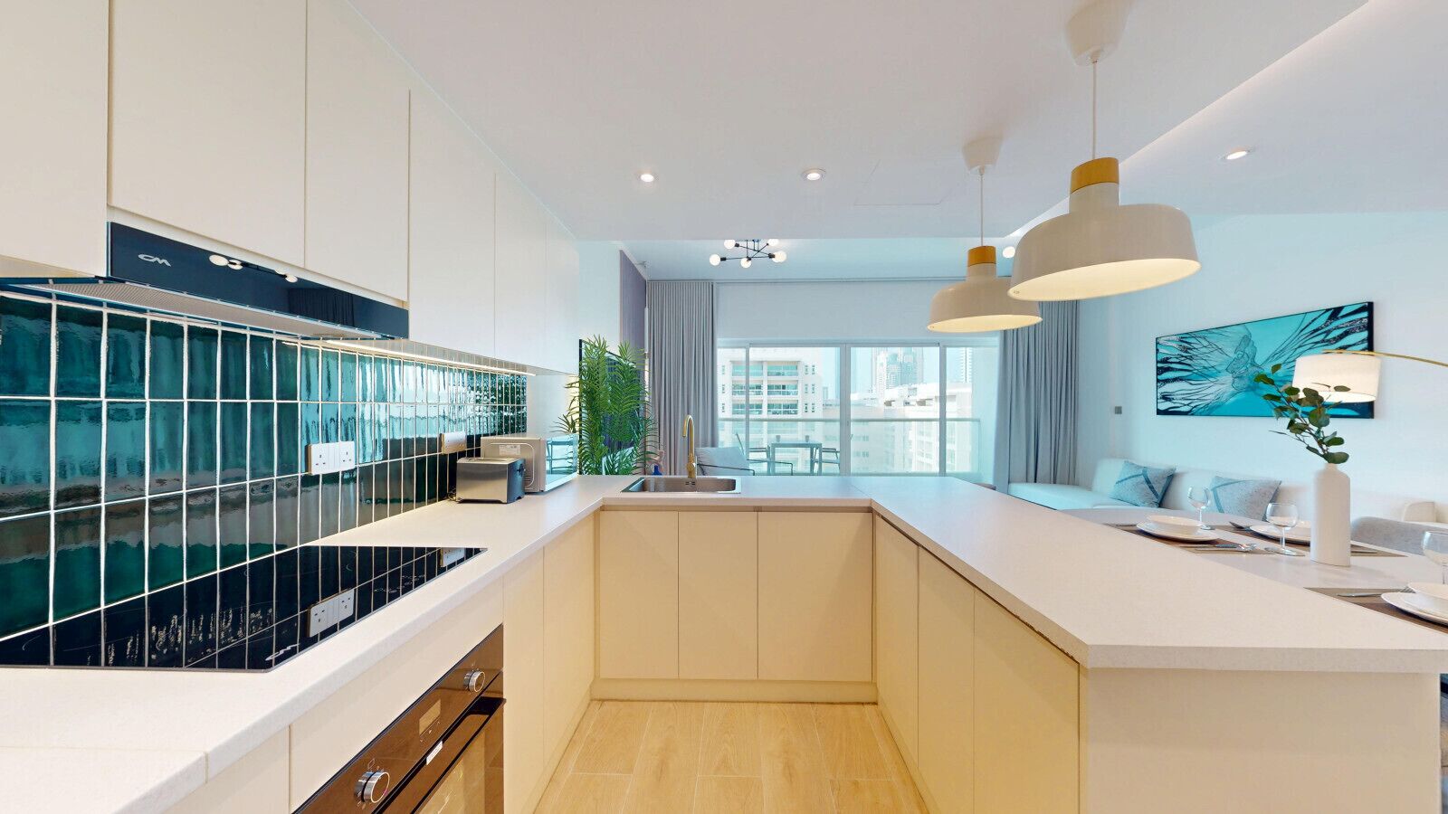 Una cocina moderna con una isla central, horno empotrado y un amplio ventanal con vista a la ciudad.