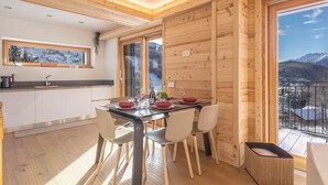 Una cocina moderna con paredes de madera y un comedor con vistas a las montañas.