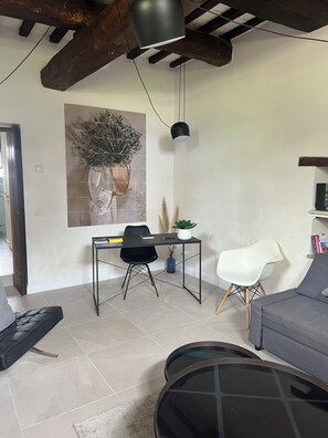 Una sala de estar moderna con una mesa de comedor, dos sillas, un sofá y una mesita de centro.